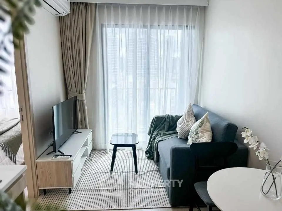 Cozy modern living room with city view, featuring sleek furniture and natural light.