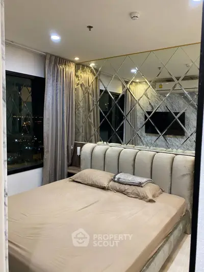 Luxurious bedroom with mirrored wall and city view, featuring elegant decor and ambient lighting.