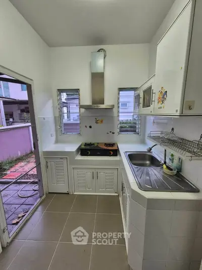 Compact kitchen with modern appliances and open layout, featuring a gas stove and ample natural light.