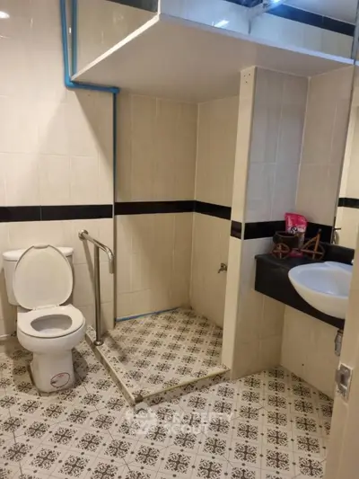 Spacious bathroom with modern fixtures and patterned tile flooring, ideal for comfort and accessibility.