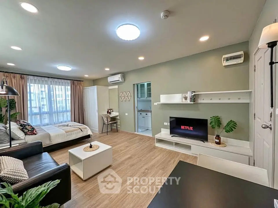 Modern studio apartment with open layout, featuring cozy living area, stylish decor, and natural light.