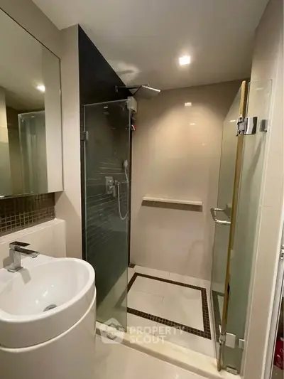 Modern bathroom with glass shower enclosure and sleek fixtures