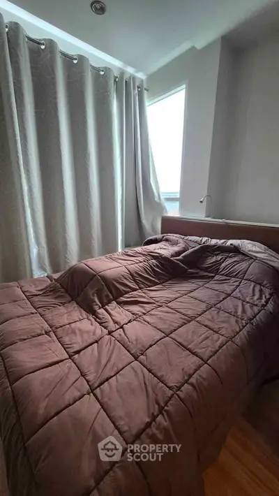 Cozy bedroom with modern decor and large window for natural light.