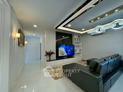 Luxurious living room with modern decor, sleek leather sofa, and large TV in elegant apartment.