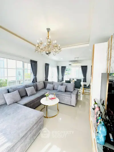 Luxurious living room with elegant chandelier and spacious gray sectional sofa