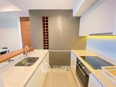 Modern kitchen with sleek design, featuring built-in oven and electric cooktop, ideal for contemporary living.