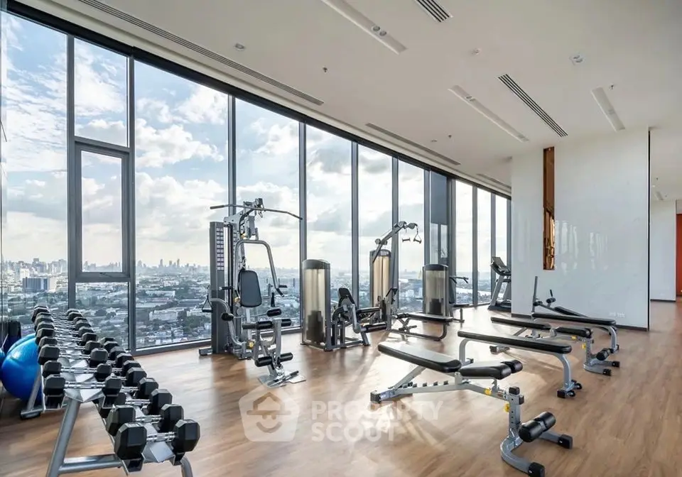 Spacious modern gym with city view and state-of-the-art equipment.