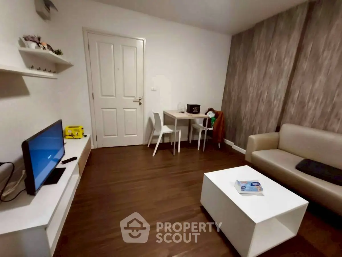 Cozy living room with modern decor, featuring a sleek TV setup and stylish furniture.