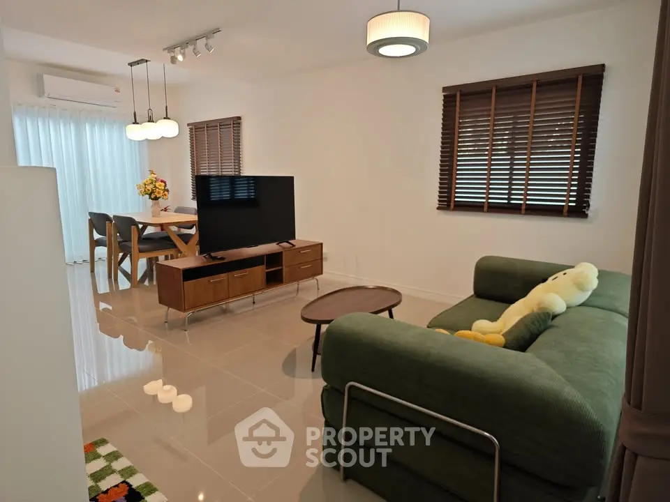 Modern living room with stylish furniture and open dining area, perfect for family gatherings.