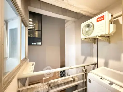 Compact balcony with air conditioning unit and washing machine in urban apartment.