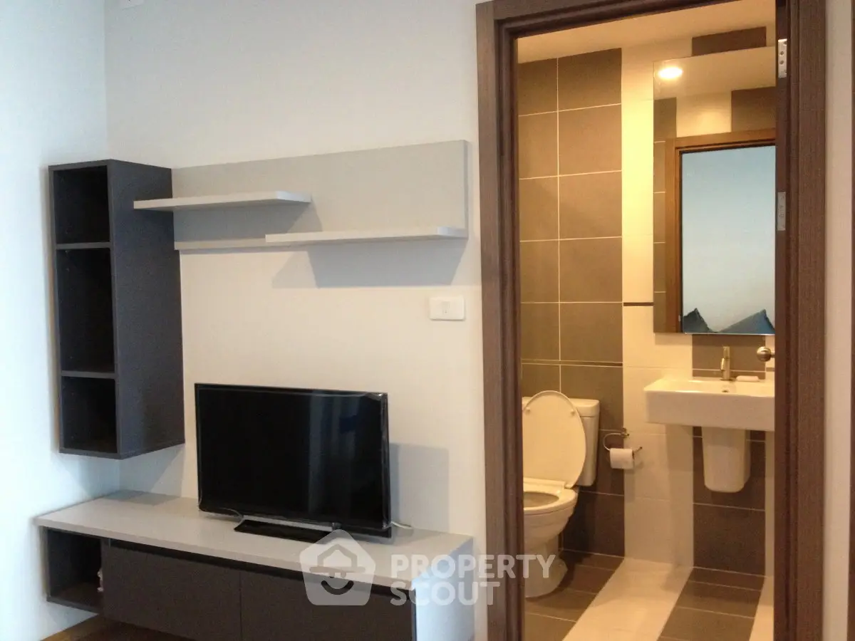 Modern apartment interior with TV and bathroom view, ideal for urban living.