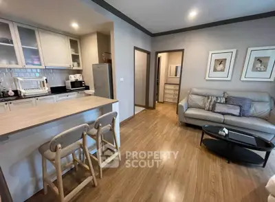 Modern open-plan living room with cozy seating and stylish kitchen area