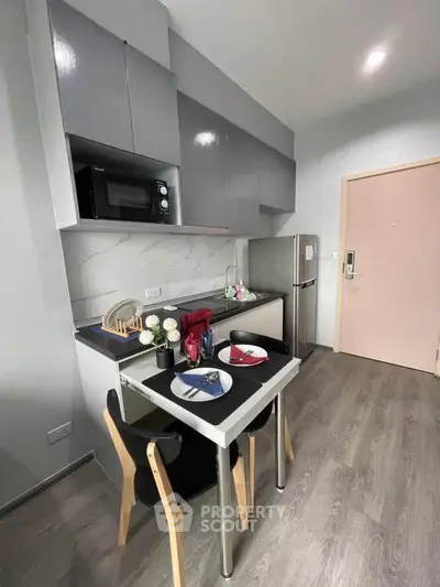 Modern compact kitchen with sleek cabinets and dining setup
