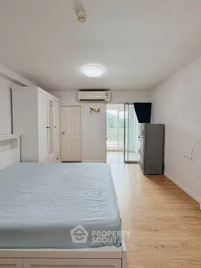 Spacious bedroom with balcony access and modern furnishings