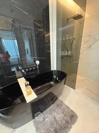 Luxurious modern bathroom with sleek black bathtub and elegant marble shower.