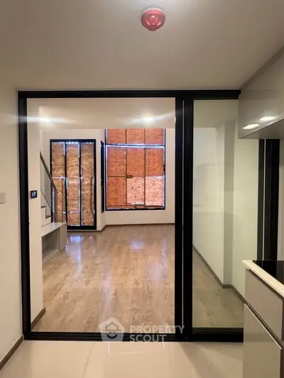 Modern interior with open layout and large windows, featuring sleek flooring and contemporary design.