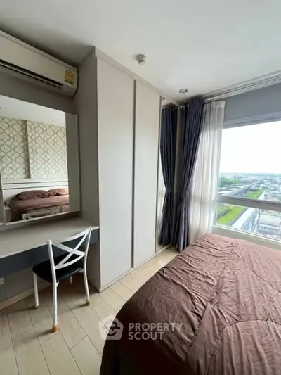 Cozy bedroom with large window offering stunning city view, featuring modern furniture and elegant decor.