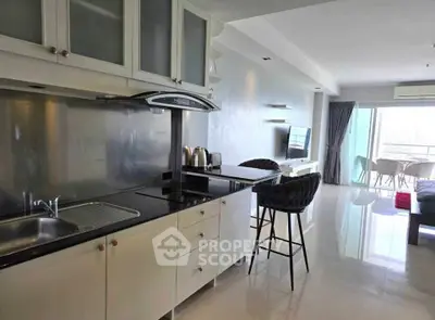 Modern open-plan kitchen and living area with sleek design and balcony view.