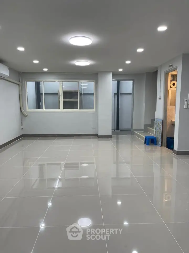 Spacious modern living room with glossy tiled floors and recessed lighting