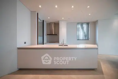 Modern minimalist kitchen with sleek island and recessed lighting