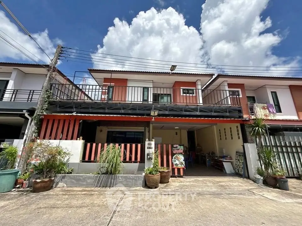 Charming townhouse with modern facade and spacious driveway under a bright blue sky.