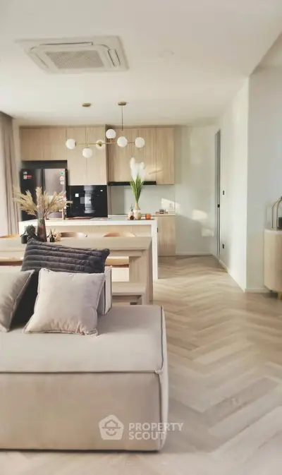 Modern open-layout kitchen and living room with stylish decor and natural light.