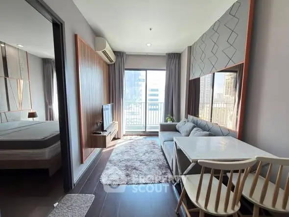 Modern living room with cozy sofa, dining area, and city view balcony in a stylish apartment.