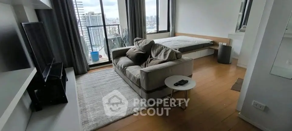 Modern studio apartment with cozy living area and city view balcony