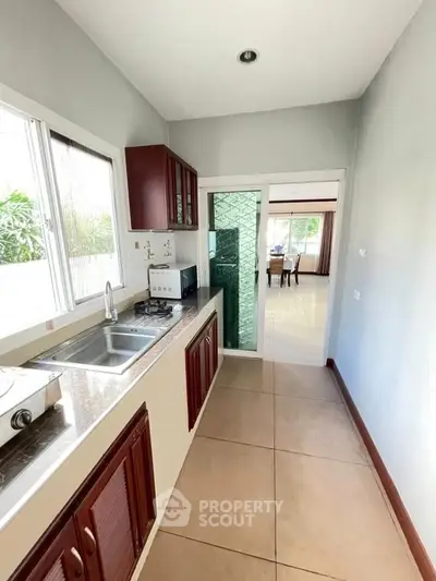 Modern kitchen with sleek design and open layout leading to dining area