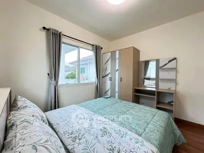 Cozy bedroom with stylish decor and ample natural light, featuring a comfortable bed and modern wardrobe.