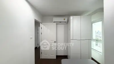 Modern bedroom with white wardrobe and air conditioning, offering a bright and airy atmosphere.