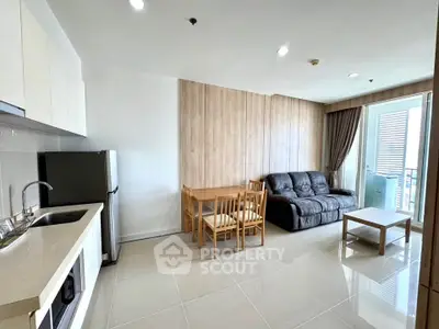 Modern open-plan living room with sleek kitchen and cozy seating area.