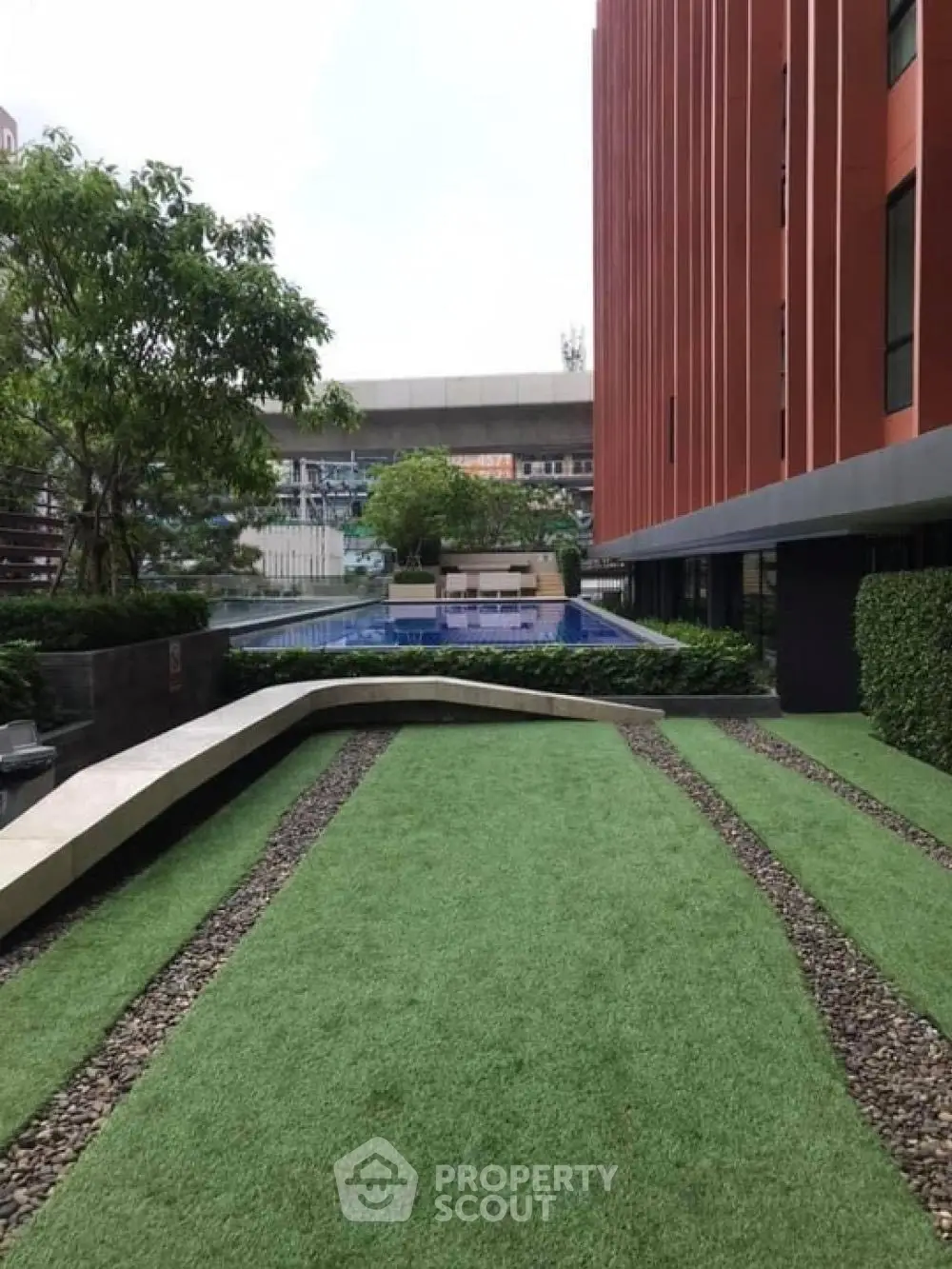 Modern apartment building with lush garden and pool view