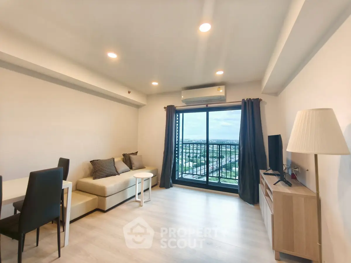 Modern living room with balcony view, stylish furniture, and abundant natural light.