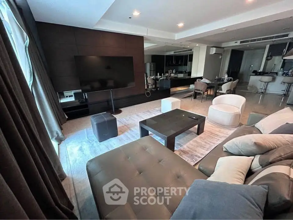 Luxurious modern living room with sleek furniture and open kitchen layout, perfect for entertaining.