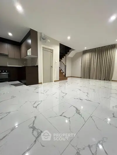 Spacious modern living room with marble flooring and open kitchen layout