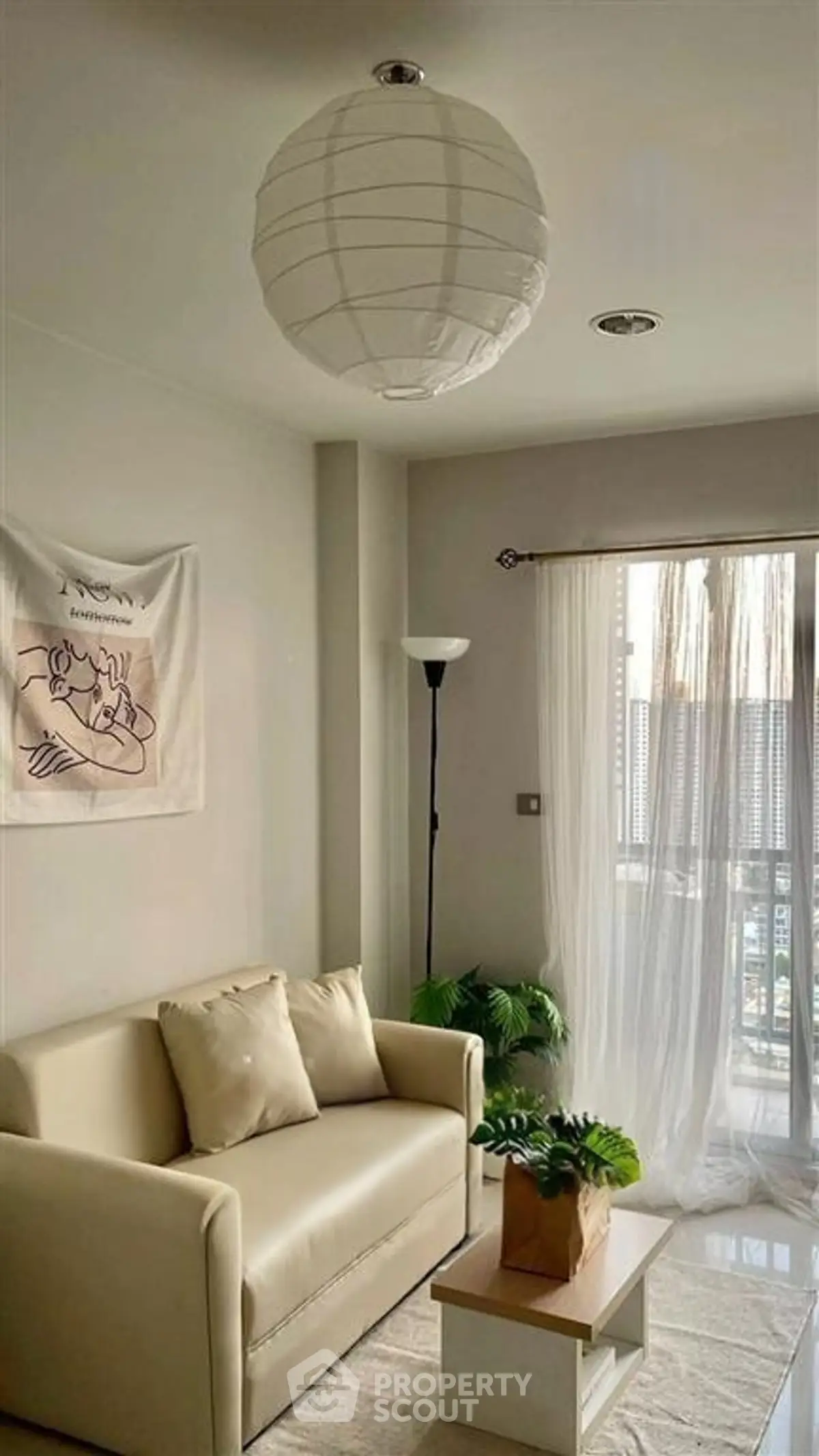 Cozy living room with modern decor and natural light, featuring a comfortable sofa and stylish lighting.