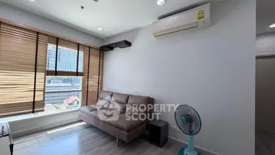 Modern living room with city view, featuring a sleek sofa and air conditioning.