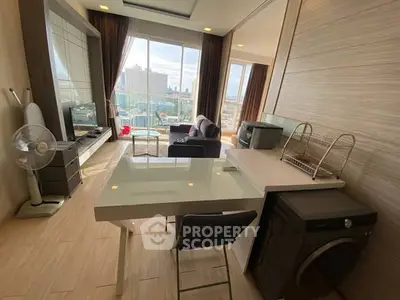 Modern living room with city view, featuring sleek furniture and integrated appliances.