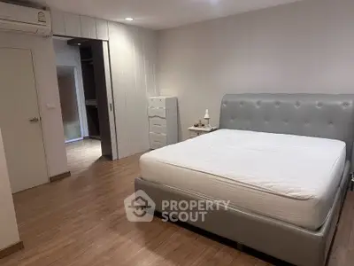 Spacious bedroom with modern decor and wooden flooring