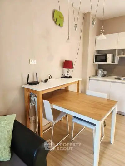 Cozy kitchen with modern dining area and stylish lighting in a compact apartment.