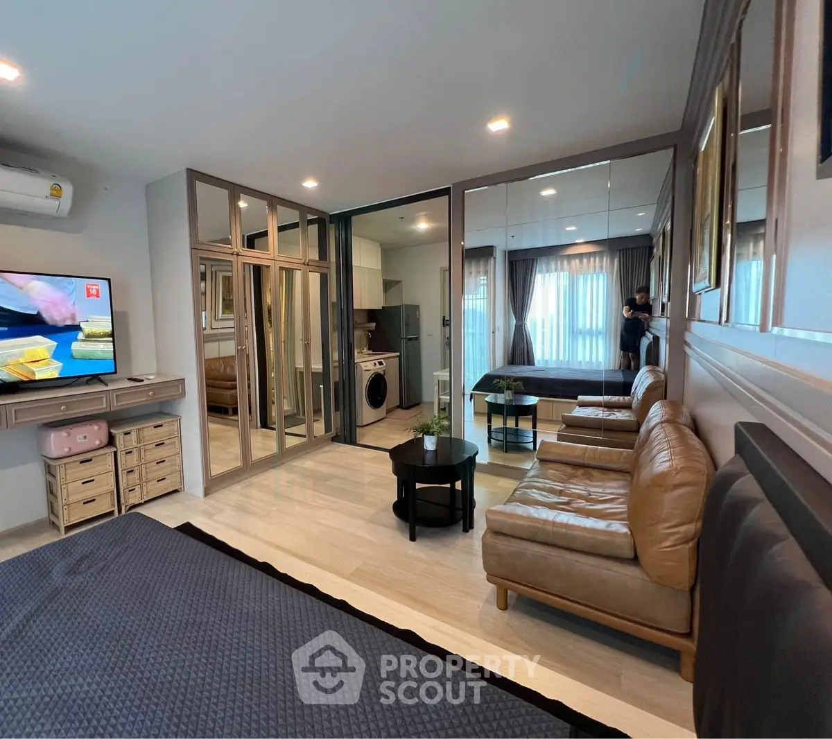 Spacious modern living room with mirrored walls and cozy seating area
