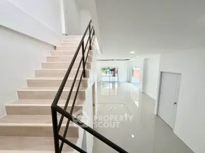 Modern minimalist interior with sleek staircase and open living space, perfect for contemporary living.