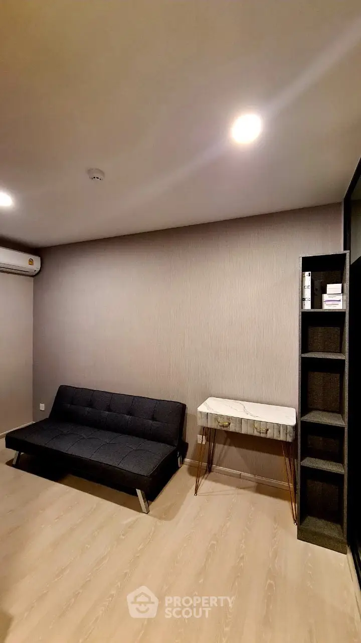 Modern minimalist living room with sleek black sofa and stylish marble table.