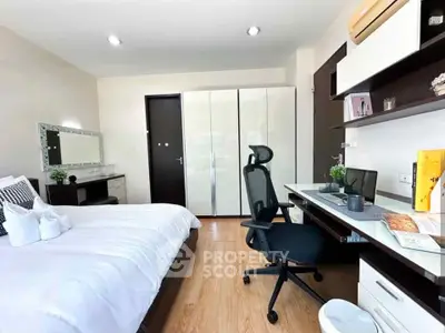 Modern bedroom with study area, sleek furniture, and ample storage space.