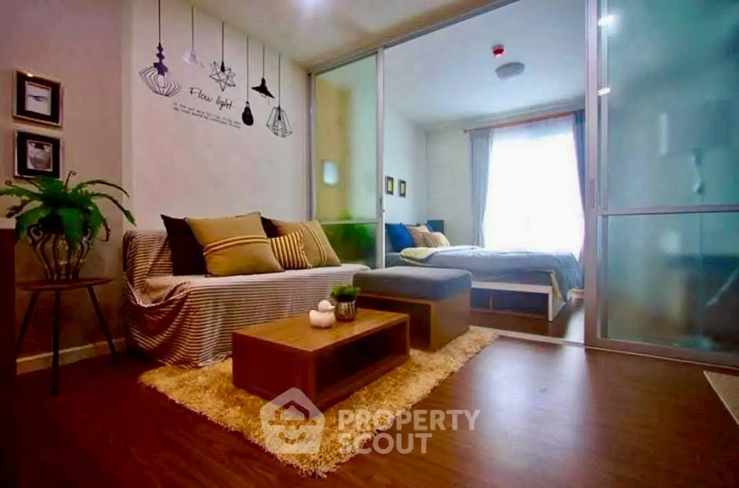 Stylish modern living room with cozy decor and sliding glass doors leading to a bright bedroom.