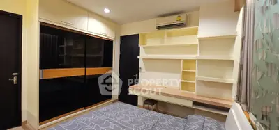 Modern bedroom with built-in wardrobe and stylish shelving, featuring a cozy bed and air conditioning.