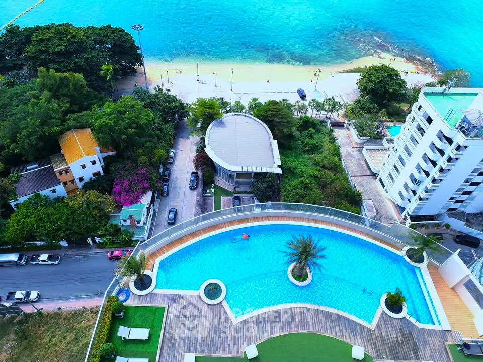 Stunning aerial view of luxury beachfront property with infinity pool and lush surroundings.
