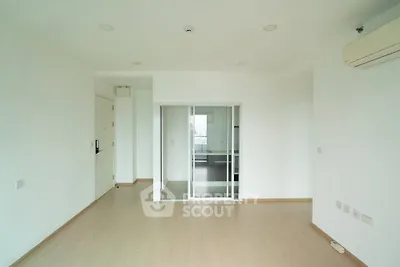 Spacious minimalist living room with sliding glass doors and air conditioning
