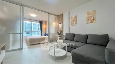 Modern living room with sleek design and cozy bedroom view in stylish apartment.